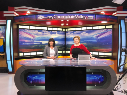 Photo of two people sitting at a desk for a news segment